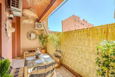 a balcony with a table and chairs and a fence at Appartement élégant et cosy in Marrakech