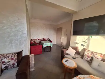 a living room with a couch and a tv on the wall at Charming Apartment at Marrakech in Marrakech