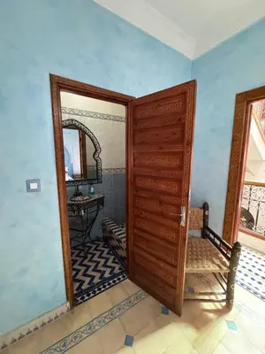 a bathroom with a wooden door and a mirror at ASA House in Marrakech