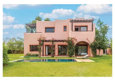 a pink house with a pool in the yard at Villa Iris Jaccuzi, Piscine 20min Centre in Marrakech