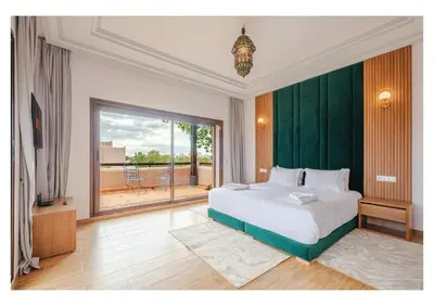 a bedroom with a large bed and a large window at Villa Iris Jaccuzi, Piscine 20min Centre in Marrakech