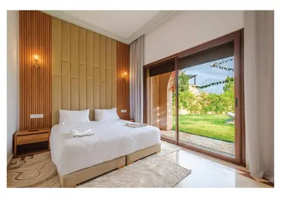 a bedroom with a large bed and a large window at Villa Iris Jaccuzi, Piscine 20min Centre in Marrakech