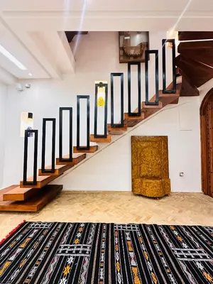 a room with a staircase with black and white canvases at Riad twaam in Marrakech