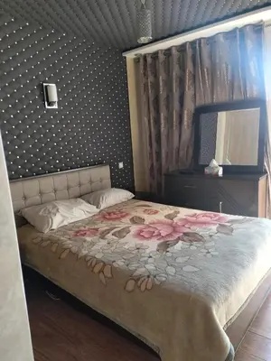 a bedroom with a large bed with flowers on it at Appartement Confort & Style à Charaf - Marrakech in Marrakech