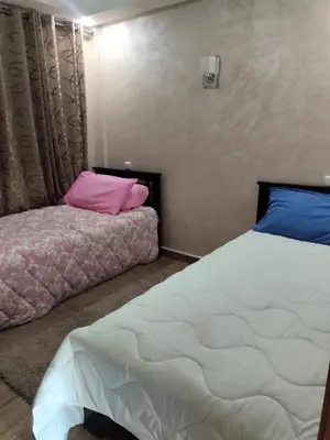 a bedroom with a bed and a pillow on the floor at Appartement Confort & Style à Charaf - Marrakech in Marrakech