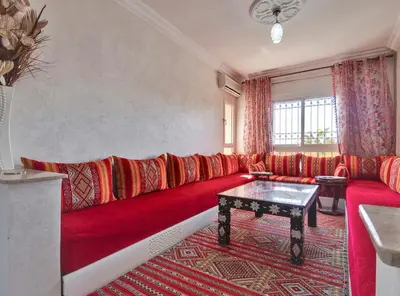 a living room with a red couch and a table at Modern 3BR Apartment 5 Min from Majorelle Garden in Marrakech