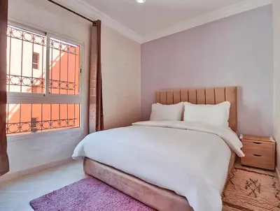 a bedroom with a large bed and a window at Modern 3BR Apartment 5 Min from Majorelle Garden in Marrakech