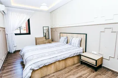 a bedroom with a large bed and a wooden floor at Migdal Jaouhara in Marrakech