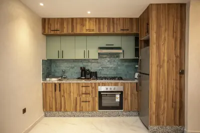 a kitchen with wooden cabinets and a refrigerator at Duplex Majorella in Marrakech