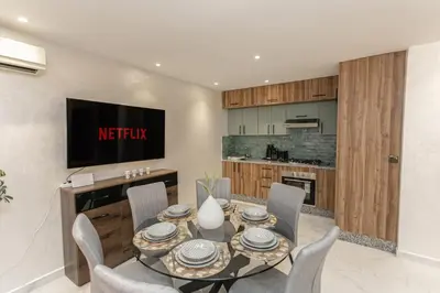 a dining room with a table and chairs and a tv at Duplex Majorella in Marrakech