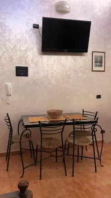 a table and chairs with a television on a wall at Dar DAROUNE in Marrakech