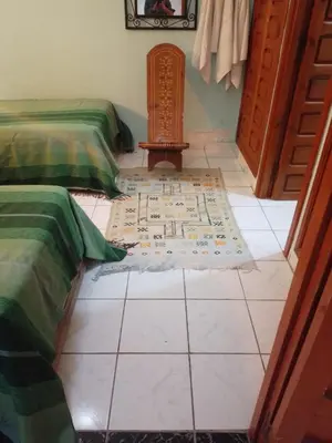 a room with two beds and a rug on the floor at Riad avec jardins et piscines in Marrakech