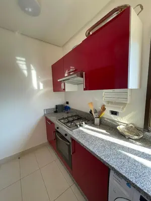 a kitchen with red cabinets and a stove top oven at Prestigia golf in Marrakech