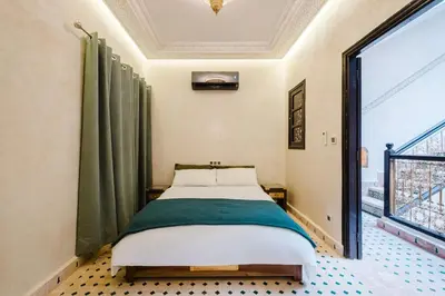 a bedroom with a bed and a large window at Riad Emeraude Cozy Riad with Shared Pool 4 Room in Marrakech