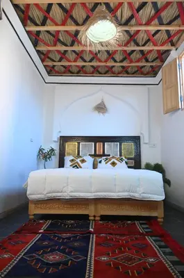 a bedroom with a king sized bed with a ceiling at dar dmana in Marrakech
