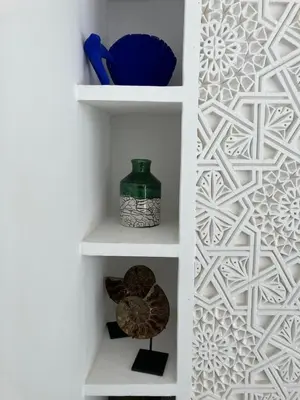 a white shelf with a green vase on it at Riad de luxe PAMA au cœur de la médina Marrakech in Marrakech