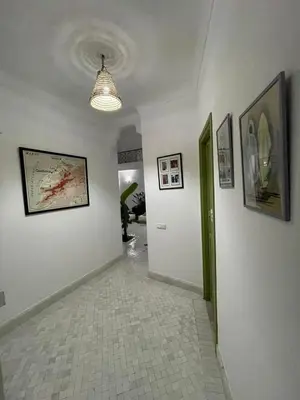 a hallway with white walls and pictures on the walls at Riad de luxe PAMA au cœur de la médina Marrakech in Marrakech