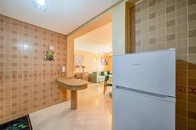 a kitchen with a refrigerator and a table in it at Cocon De Luxe Proche du Centre in Marrakech