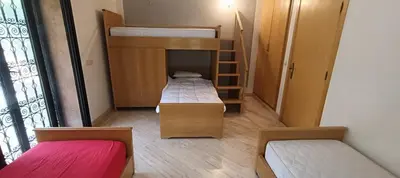 a small room with two bunk beds and a staircase at Rez-de-chaussée avec piscine in Marrakech