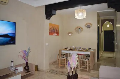 a living room with a table and a dining room at Golden Palms Marrakech in Marrakech