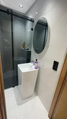 a white bathroom with a sink and a mirror at Appartement a marrakech gueliz au centre ville in Marrakech