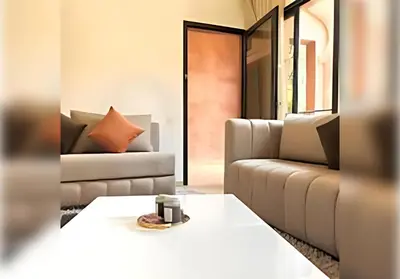 a living room with a couch and a table at Ehden Properties - Appt spacieux dans la prestigieuse River Palm Marrakech in Marrakech