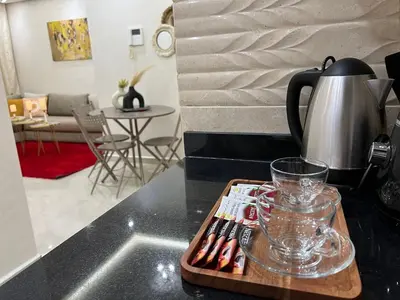 a kitchen counter with a tray with a tea pot and a glass at Cozy and convenient apartment in Marrakech