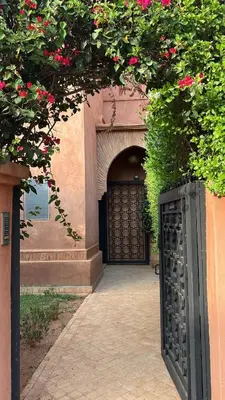 an entrance to a building with a black door with flowers at Villa Oasis Marrakesh in Marrakech