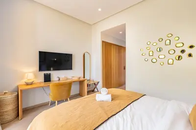 a bedroom with a bed and a desk and a television at Villa Aila Elegant 6 Bedrooms Spa, Cinema Pool in Marrakech