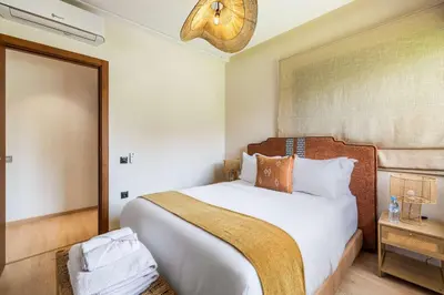 a bedroom with a large white bed in a room at Charme Marrakchi - Piscine, Jardin & Espace Sport in Marrakech