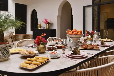 a table with food and bread and fruit on it at Riad Arraha Retreat Elegance tranquility and pools in Marrakech