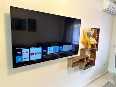 a large flat screen tv hanging on a wall at Appartement charmant au cœur de Marrakech in Marrakech