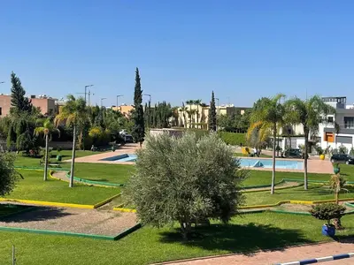 a park with a swimming pool and palm trees at Villa Marrakech avec Piscine in Marrakech