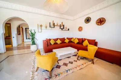 a living room with a red couch and yellow chairs at luxury gueliz in Marrakech