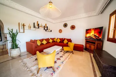 a living room with a red couch and yellow chairs at luxury gueliz in Marrakech