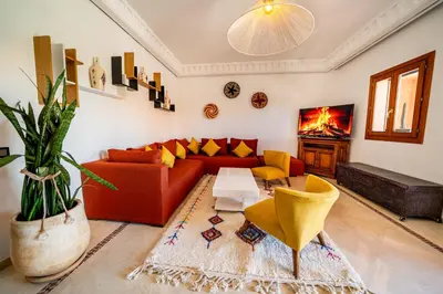 a living room with a red couch and yellow chairs at luxury gueliz in Marrakech