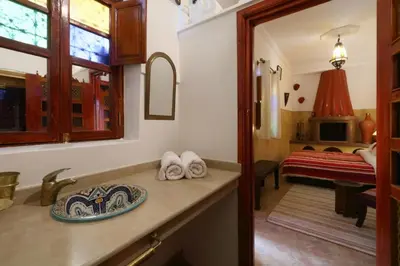 a bathroom with a sink and a room with a bed at Naima's House in Marrakech