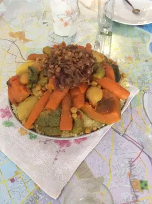a plate of food with carrots and beans on a table at Naima's House in Marrakech