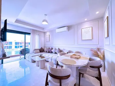 a living room with a couch and a table and chairs at New! apptÉlégance ,Lumière et Confort avec piscine in Marrakech