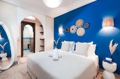 a bedroom with a white bed and a blue wall at Riad Sahar Privé - Piscine Chauffée Sup - PDJ Inclus in Marrakech