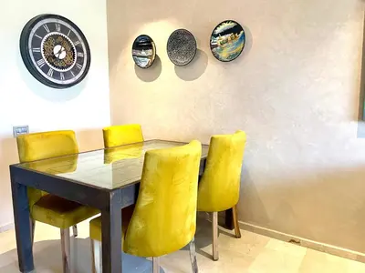 a dining room with a table and yellow chairs at Prestigia aghat in Marrakech