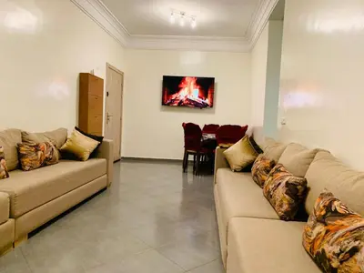 a living room with two couches and a table at Spacious apartment 15 minutes from aéroport Marrakech reservation juste pour les familles est les couples mariés in Marrakech