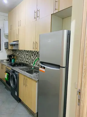 a kitchen with a refrigerator and a sink at Spacious apartment 15 minutes from aéroport Marrakech reservation juste pour les familles est les couples mariés in Marrakech