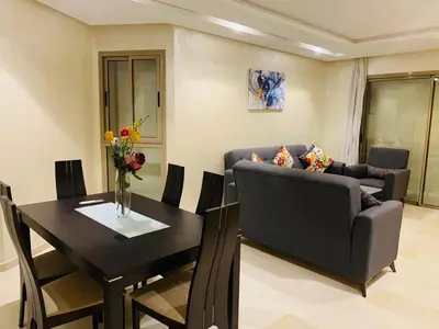 a living room with a couch and a table at Prestigious new 3-bedroom apartment with pool view in Marrakech