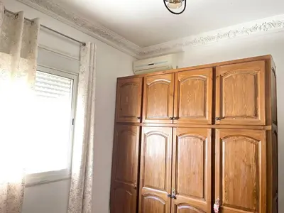 a large wooden cabinet in a room with a window at luxury marrakech in Marrakech