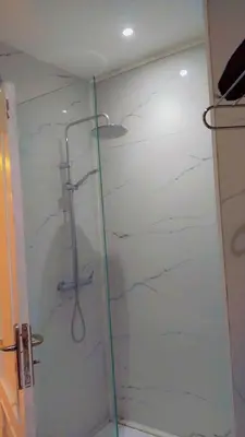 a shower with a glass door in a bathroom at شقة مفروشة in Marrakech