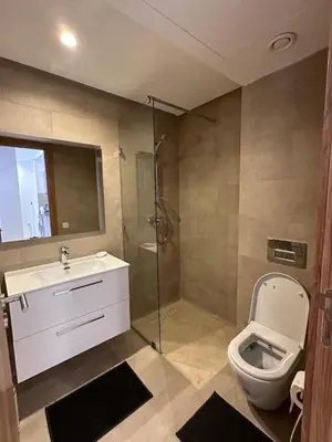 a bathroom with a toilet and a sink and a shower at Noria Golf Poolside Garden Flat in Marrakech