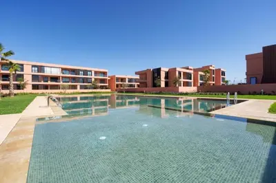 a large swimming pool in front of a building at Noria Golf Poolside Garden Flat in Marrakech