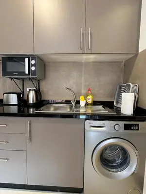 a kitchen with a washing machine and a sink at Noria Golf Poolside Garden Flat in Marrakech