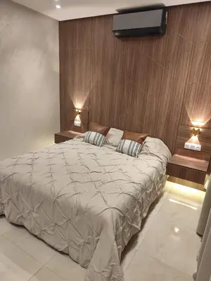 a bedroom with a large bed with two lights on it at Apartment 5 minutes from Marrakech Airport in Marrakech